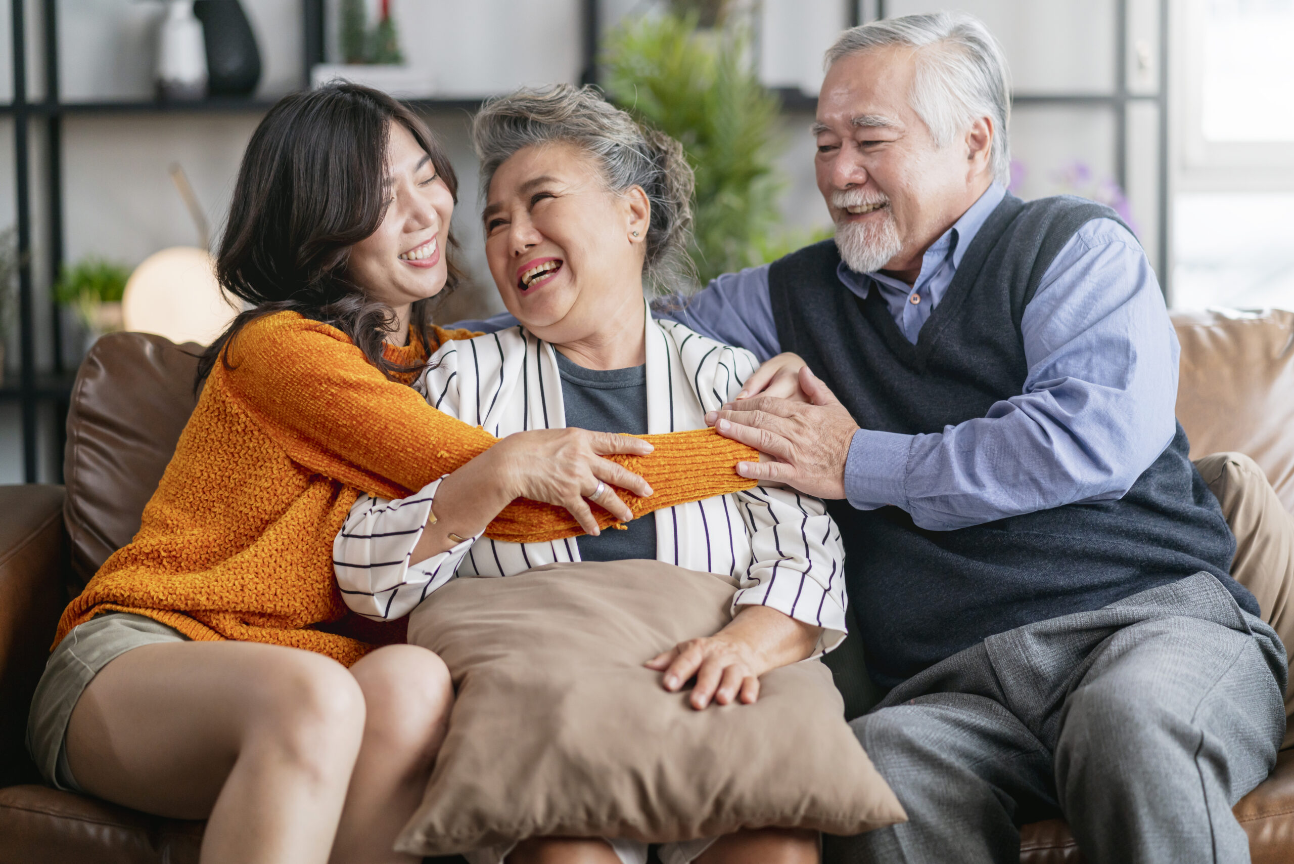 happiness-asian-family-candid-daughter-hug-grandparent-mother-farther-senior-elder-cozy-relax-sofa-couch-surprise-visiting-living-room-hometogether-hug-cheerful-asian-family-home-scaled